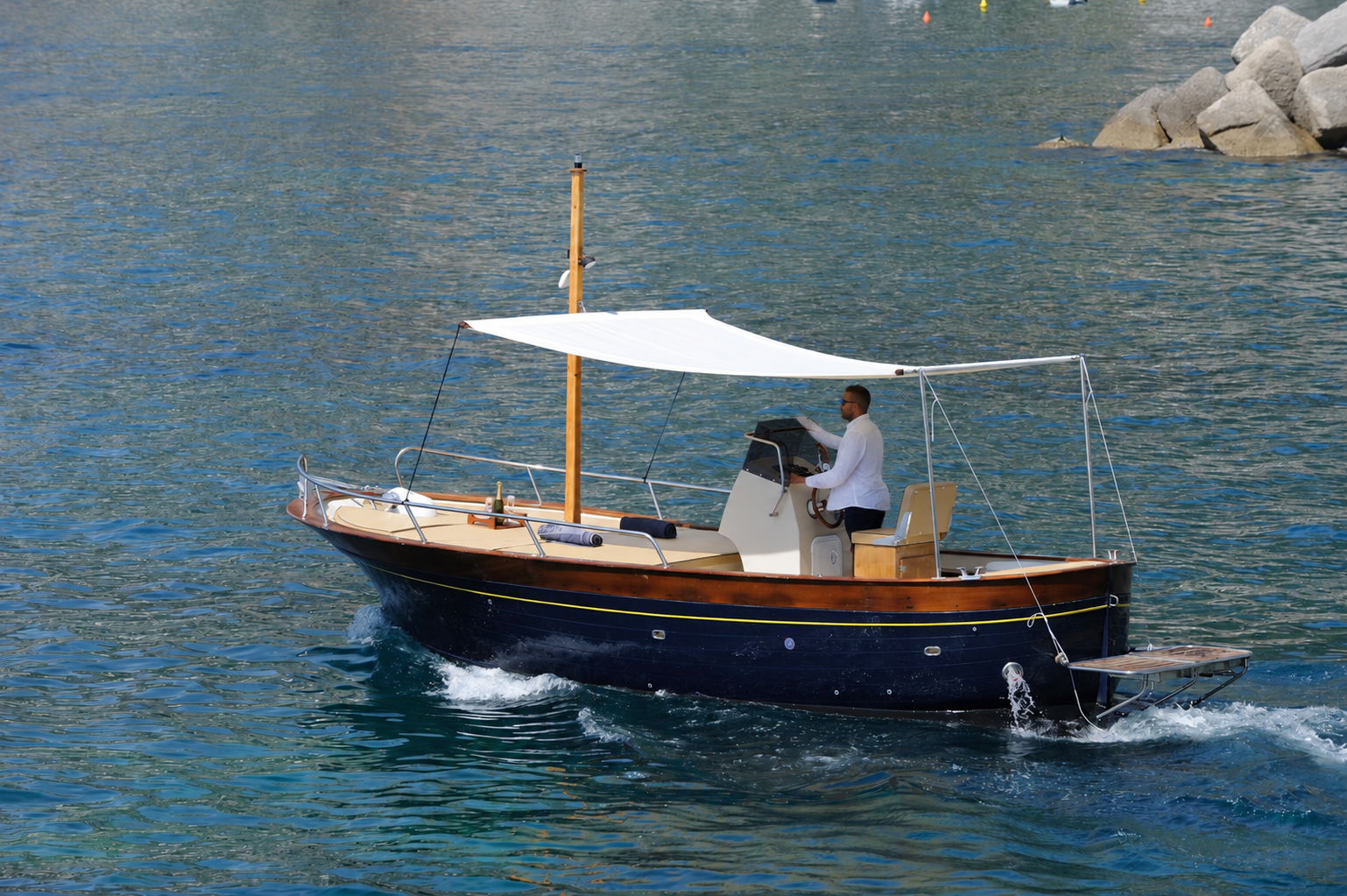 Small private boat cruising along the coast